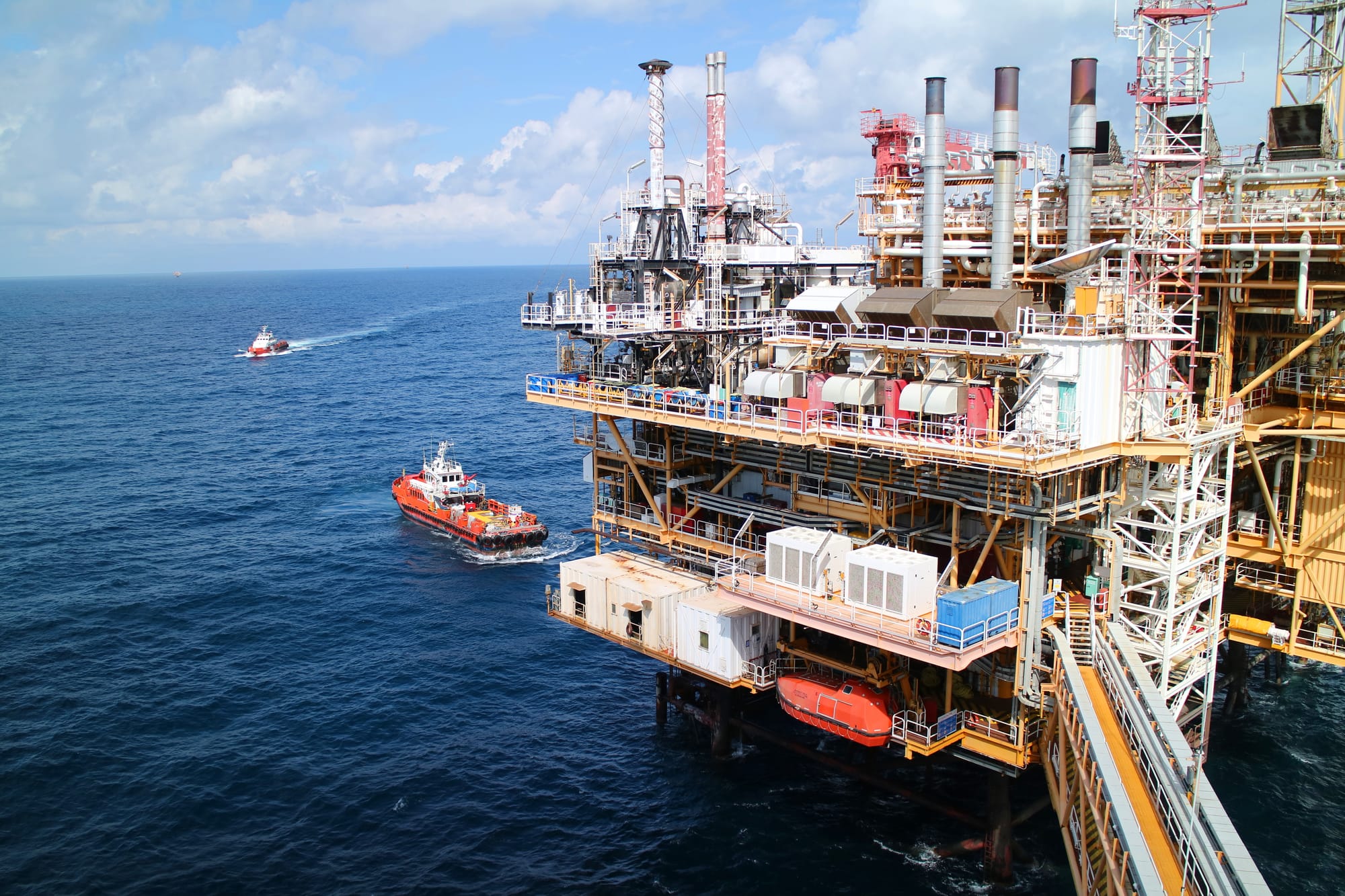 Supply boats coming and going from an oil and gas drilling platform in Gulf waters.