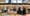 Blurry image of a convenience store interior with customers at the checkout counter and shelves stocked with various products.