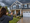 A woman photographing the exterior of a house with her cell phone before a storm.